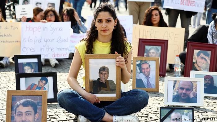 Syrian woman Sedra Alshehabi with a picture of her missing father at a Berlin protest