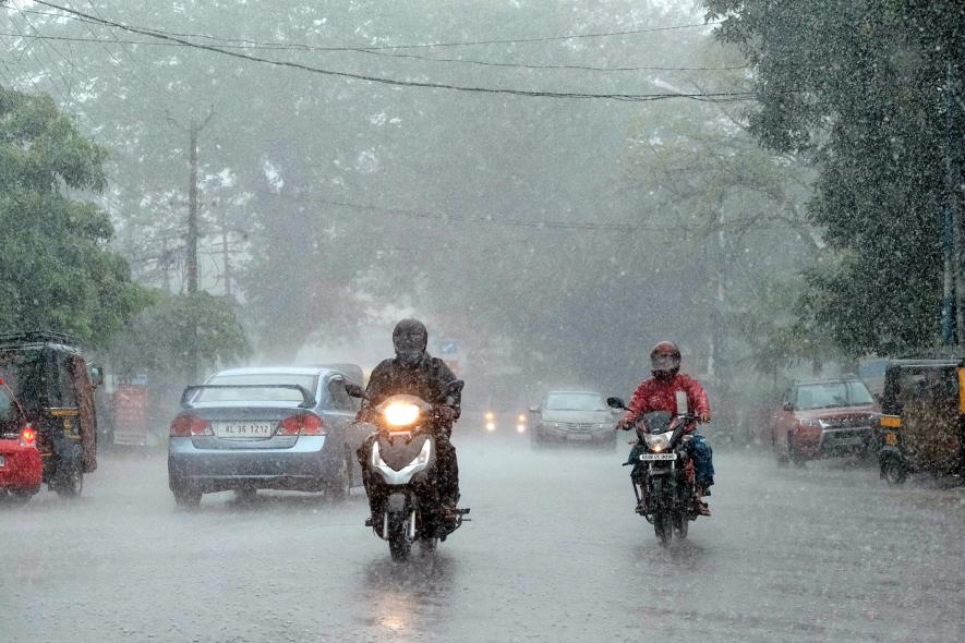 Vehicles move on the road during heavy rain in Kochi