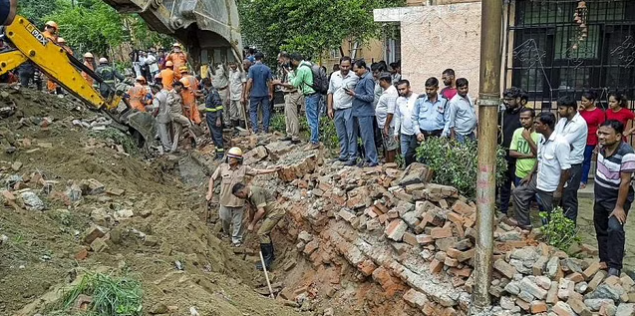 Rescue operation underway after a portion of a boundary wall of a housing society collapsed, at Jal Vayu Vihar in Noida
