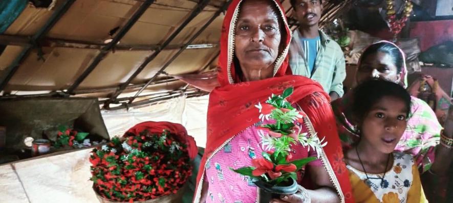 A Bawari woman with artificial flower pots that she sells for a living.