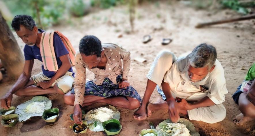 Villagers sit cross-legged enjoying a meal (Photo - Prativa Ghosh, 101Reporters).