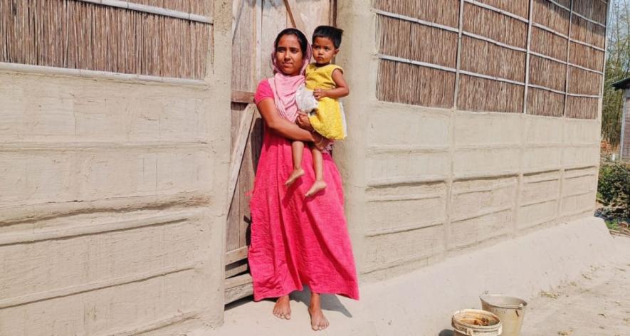 Muklesa Parveen with her daughter outside their hut in Assam's Bihagaon Chapori. Parveen's house was destroyed during last year's floods, which she rebuilt a few months ago.
